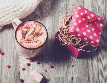 Gift box next to mug of hot cocoa